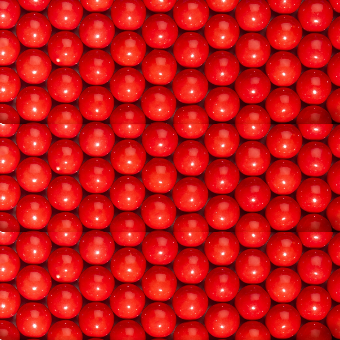 Close-up of a large number of red gumballs.